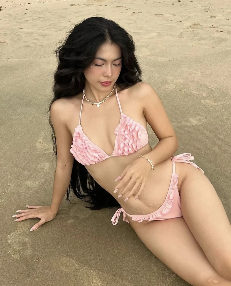 Hình gái xinh mặc bikini hồng nằm trên cát